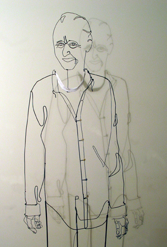 Figurative wire sculpture of standing man with white collar